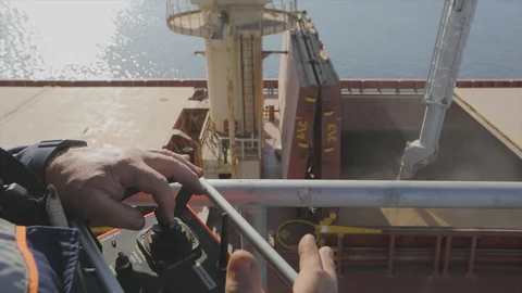 A man controls the loading of wheat into a ship. Loading wheat into a cargo ship Stock Footage 120164750