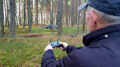 A man controls a quadrocopter in the forest. Stock Footage 117995596