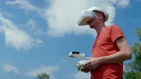 Man controls quadrocopter through remote control. Blue sky on the background Stock Footage 134921159