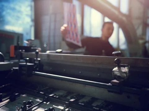Man controls wide industrial printer in workshop Foto stock