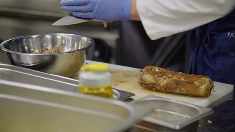 Man cook cutting cooked meat into pieces while standing restaurant kitchen. Stock Footage 121277805