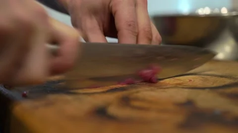 A man, a cook, in the kitchen, quickly cuts pork meat on a cutting board Stock Footage 141099188