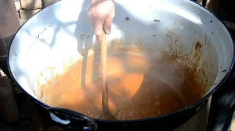 Man cooked stew in a big cauldron Stock Footage 43257594