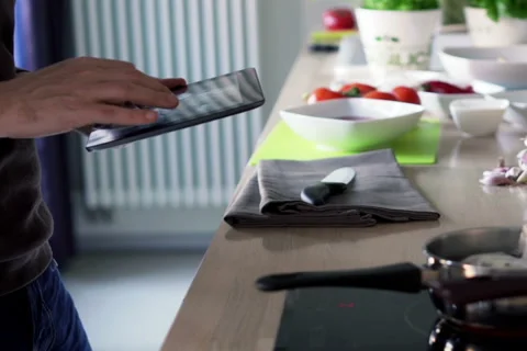 Man cooking and checking recipe on tablet computer in kitchen at home NTSC Vídeos de archivo 49551017