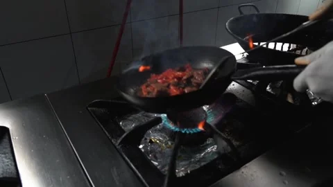 Man cooking and mixing vegetables and beef on a hot pan Stock Footage 230080499