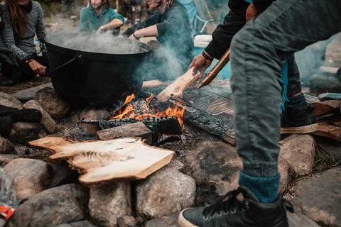 Man cooking breakfast on campfire Stock Photos