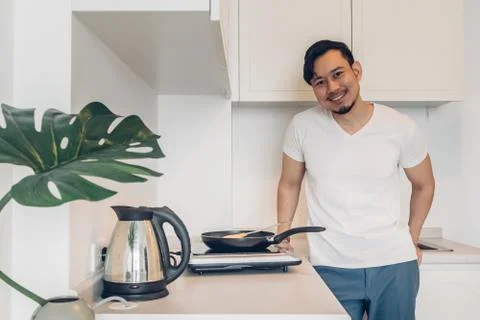 Man is cooking breakfast in the kitchen. Stockfoto's