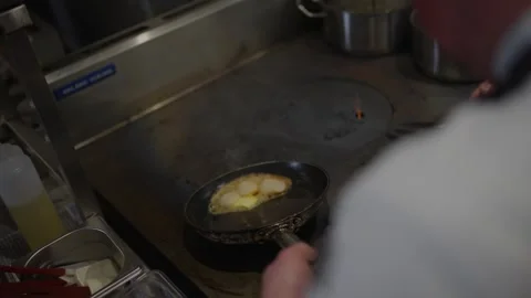 A man is cooking eggs in a pan Stock Footage 306577125