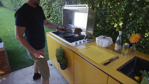 A man is cooking on a grill outside Stock Footage 297871943