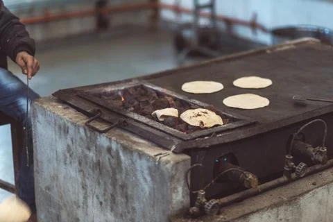 Man cooking Indian flat bread, called chapati, and roasting it on live flame. Stock Photos