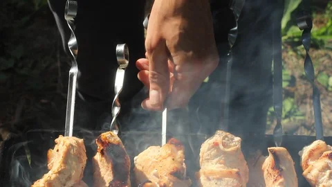 Man cooking meat on grill. Bbq on hot flames. Picnic concept. Stock Footage 112038847