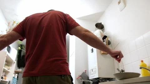 Man cooking in a modern kitchen  red shirt cooking action sequence Stock Footage 307447605