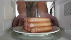 Cooking sausages in the microwave oven i... | Stock Video | Pond5