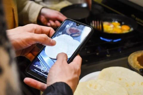 Man cooking while his taking a photo of his arepas Stock Photos
