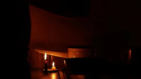 Man cooks candlelit dinner without power after missile attack Stock Footage 293357041