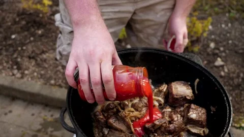 A man cooks fried meat in a pan with sauce and beer. 4K shooting Stock Footage 131875422