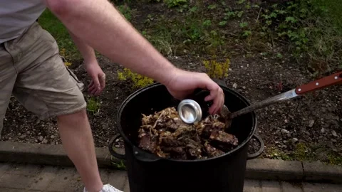 A man cooks fried meat in a pan with sauce and beer. 4K shooting Stock Footage 131875544