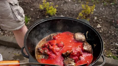A man cooks fried meat in a pan with sauce and beer. 4K shooting Stock Footage 131876002