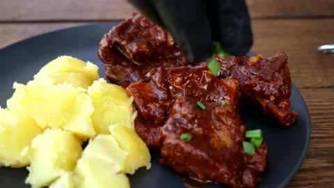A man cooks fried meat in a pan with sauce and beer. 4K shooting Stock Footage 131876135