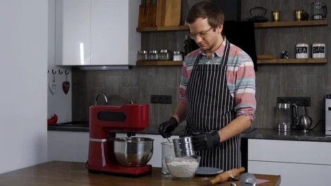 A man cooks in his kitchen. The process of making the dough for later baking Stock Footage 124005146