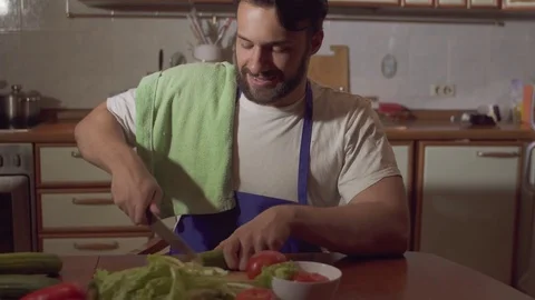 A man cooks in the kitchen he cuts vegetables Stock Footage 71641997