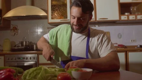 A man cooks in the kitchen he cuts vegetables Video stock 71642105