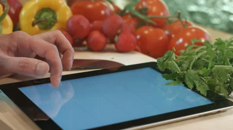 Man cooks looking writes prescriptions for a Tablet PC. salad cooking. Video stock 62348191