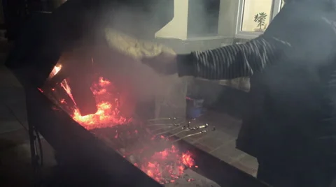 A man cooks meat over open fire BBQ 스톡 동영상 58557317
