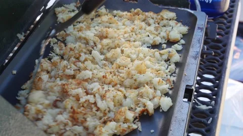 Man cooks potato hash browns while camping Stock Footage