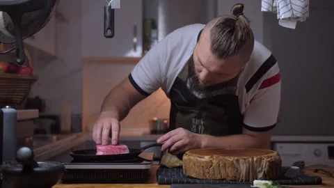 A man cooks tuna in a kitchen Stock Footage 258735368