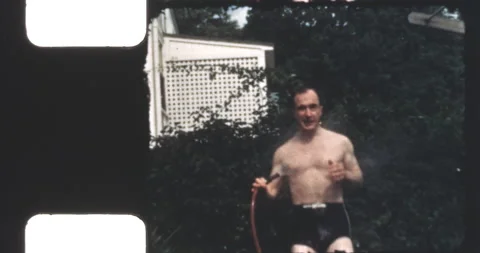 Man cooling down using garden hose Stock Footage 199390723