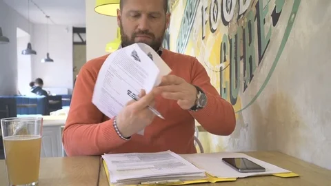 Man copy data from smartphone to documents, portrait, in cafe, steadycam Vidéo 73265483