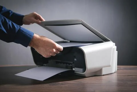 Man copying and scanning documents in office. Stock Photos