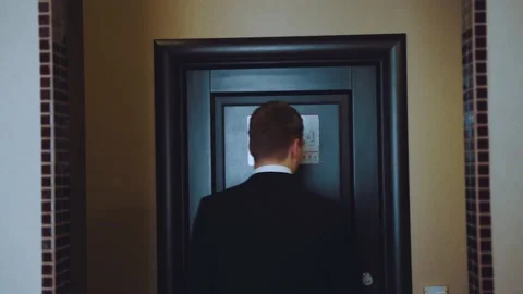 The man corrects the butterfly in front of the mirror and leaves the apartment Stock Footage 219377665