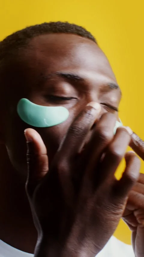 A man corrects moisturizing patches under his eyes - Care. Stock Footage 323939902