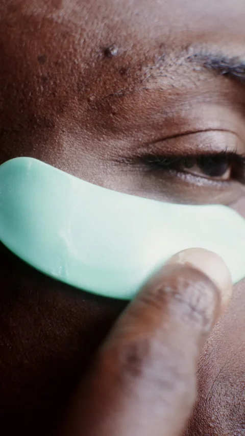A man corrects moisturizing patches under his eyes - Care. Stock Footage 323939904