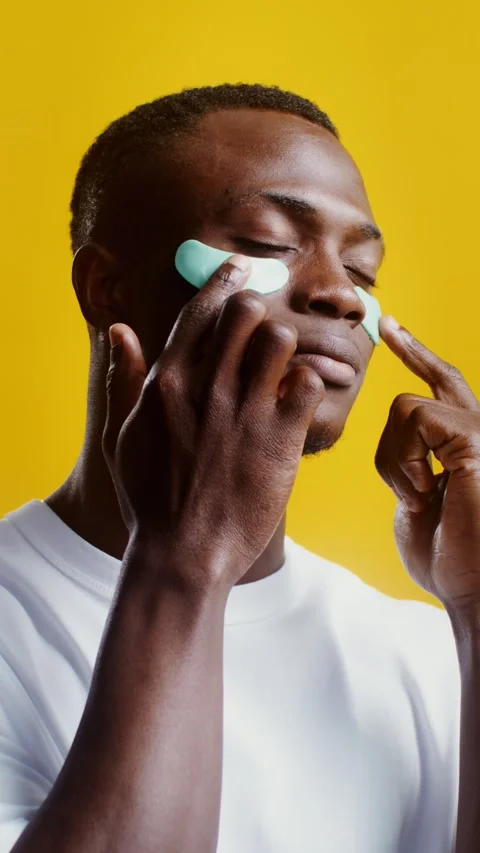 A man corrects moisturizing patches under his eyes - Care. Stock Footage 323940302