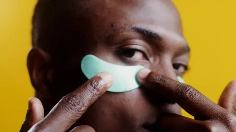 A man corrects moisturizing patches under his eyescloseup - Care. Stock Footage 323940387