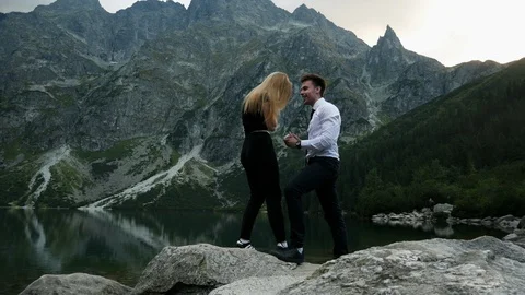 Man in costume getting down on his knee and makes a marriage proposal to his Stock Footage 119177926