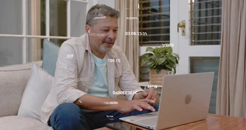 Man on couch joining remote call on laptop, speaking, typing while hex overlays Stock Footage 322203318