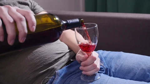 A man on the couch pours wine Stock Footage 122848121