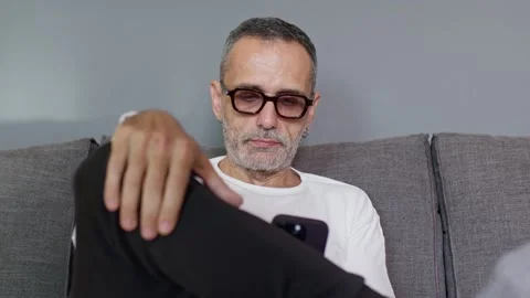 Man on couch with smartphone. Stock Footage 220464978