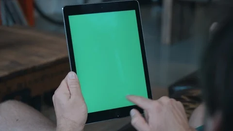 Man on couch using tablet with green screen Stock-Footage 97735935