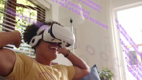 Man on couch using VR demo, purple UI appearing, laughing, raising hands, Stock Footage 332978451