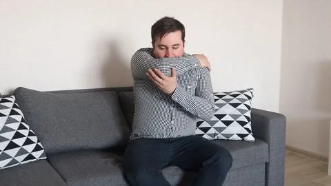 Man coughing to elbow to prevent the spread of germs Stock Footage 126711262
