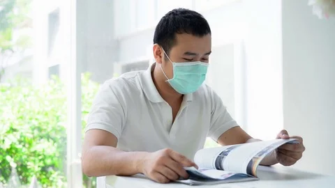 Man Coughing in His Mask while Reading Part 3 Stock Footage
