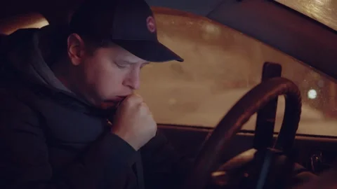 Man coughs while driving a car Stock Footage 147669388