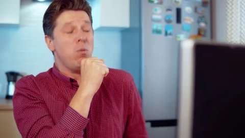 Man coughs while working at the computer Stock Footage 145138225