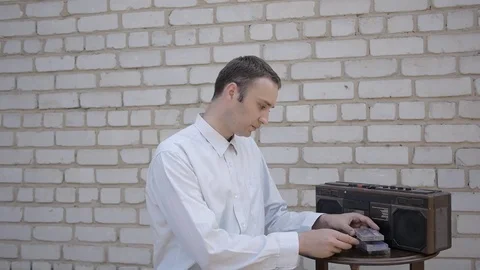 The man could not insert a cassette in an old cassette tape recorder. Stock Footage 69777999