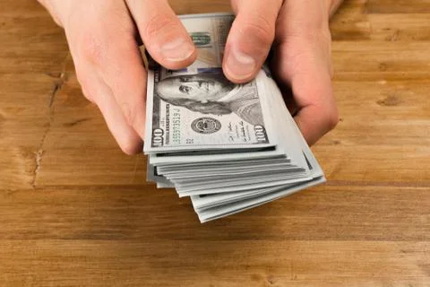 Man count the new us dollars on wooden table Stock Photos
